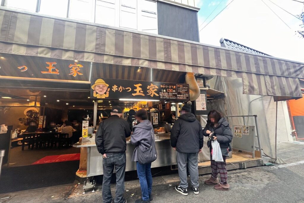 玉屋の串カツを外カウンターで食べ歩きしている様子